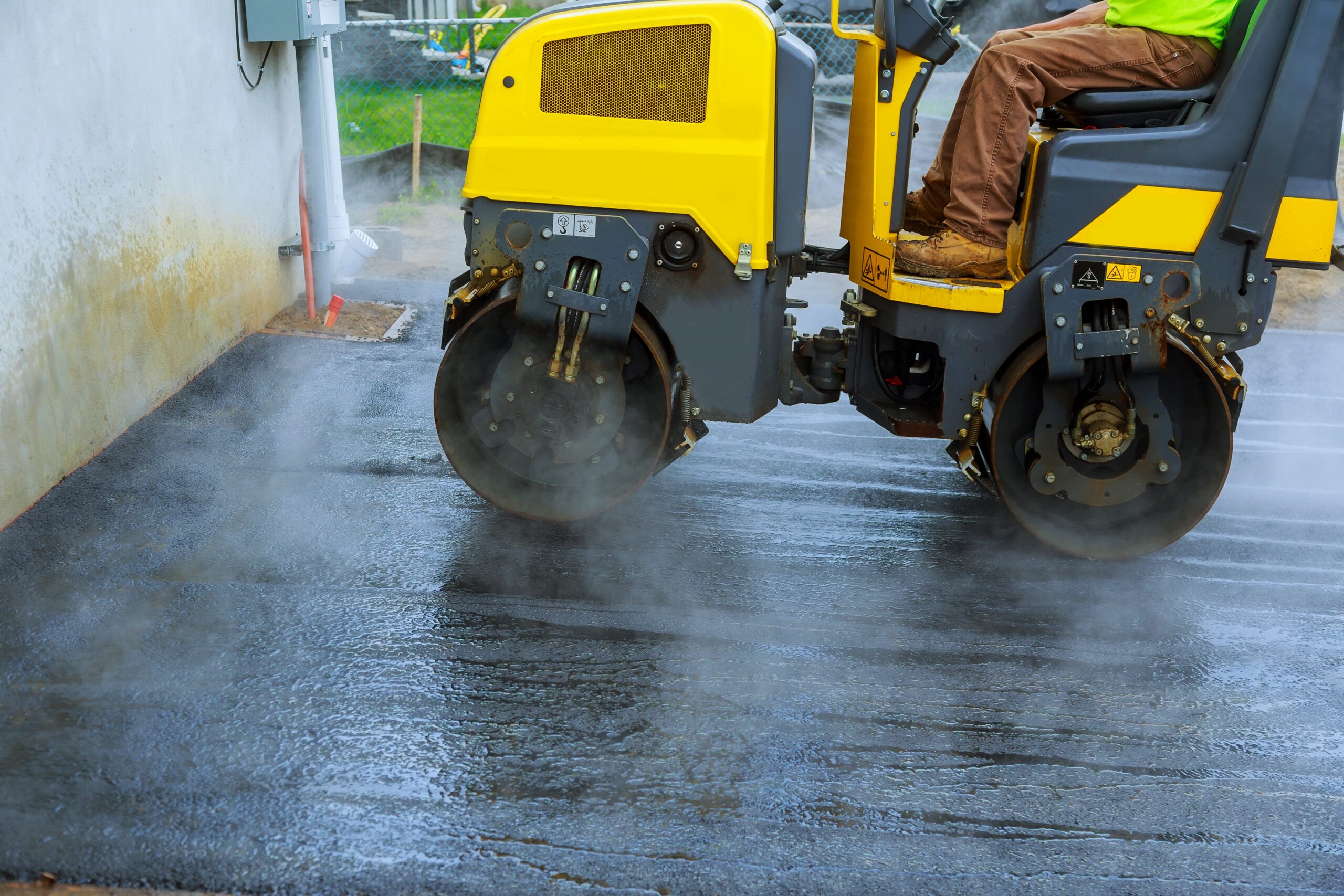 Road construction works with roller compactor machine and asphalt finisher asphalt parking for the car Road construction works with roller compactor machine and asphalt finisher asphalt parking for the car